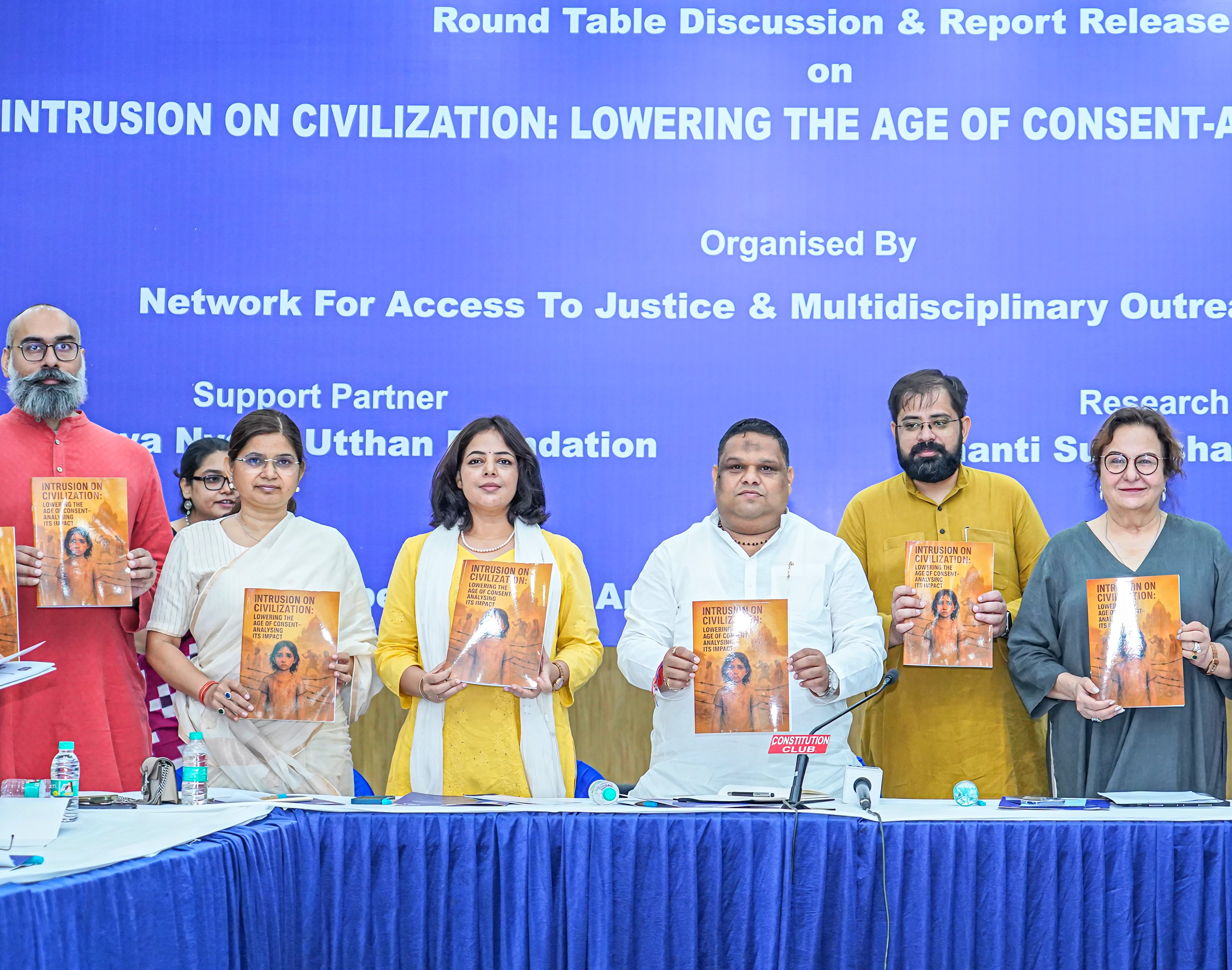 Participants holding a report at a round-table discussion on the age of consent.